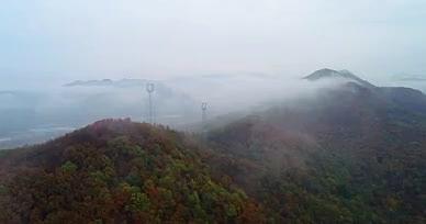 航拍穿云秋季云雾中的群山铁塔视频的预览图